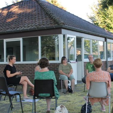 een groep mensen zitten in een kring