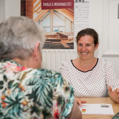 een jonge vrouw geeft uitleg aan een oud vrouw