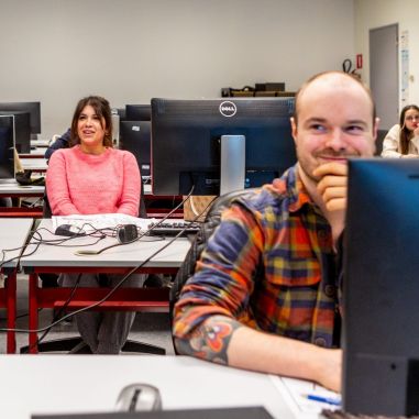 Cursisten in een klaslokaal met computers