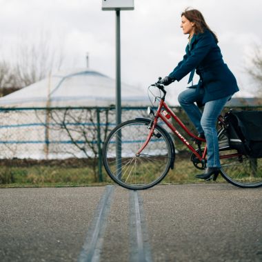 Een fietser rijdt over de telslang bij een vast telapparaat.