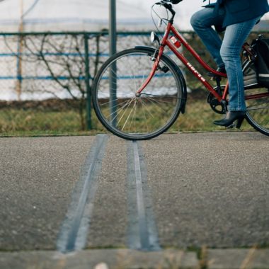 Een fietser rijdt over de telslang bij een vast telapparaat.