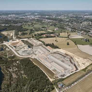 Een luchtfoto toont een lappendeken aan grondgebruik. Centraal zijn enkele actieve kleigroeves zichtbaar. Deze zijn omzoomd door akkers, weiden en beboste zones met volgelopen voormalige kleiputten. Op iets grotere afstand zijn woonwijken zichtbaar. 