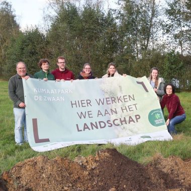 De partners van klimaatpark De Zwaan in Schoten ontvouwen een groot werfdoek bij de start van de werken.. Op het doel staat 'Klimaatpark De Zwaan. Hier werken we aan het landschap.'