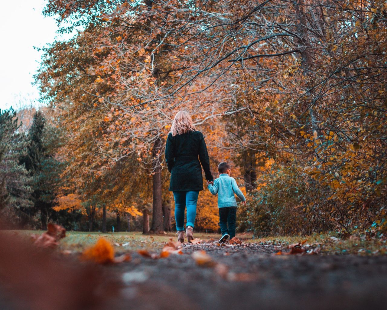 Vrouw en kind op wandel in een herfstig bos