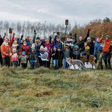 Groep kinderen plant bomen aan